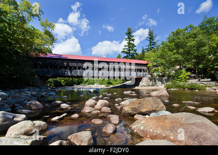 Rot gedeckten Covered Bridge überqueren einer felsigen Bucht in den White Mountains in New Hampshire Stockfoto