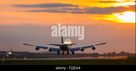 London-Heathrow, 19. September 2015. Als die Einstellung Sonne leuchtet der Himmel in einem Feiry anzeigen zu lassen, landet ein Cathay Pacific Cargo Boeing 747 Frachter am Flughafen Heathrow Runway 27R. Bildnachweis: Paul Davey/Alamy Live-Nachrichten Stockfoto