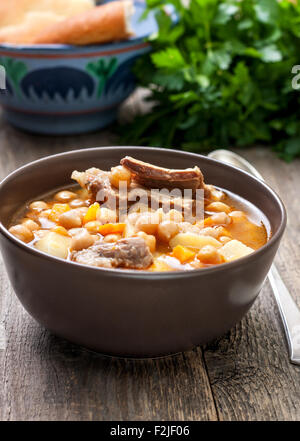 Suppe mit Kichererbsen und Lamm, Fladenbrot, Petersilie auf einem hölzernen Hintergrund Stockfoto