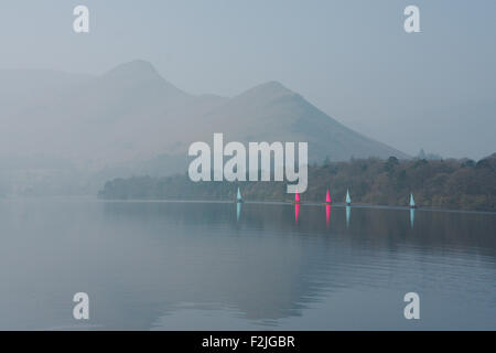 Rosa und blaue Segelboote spiegelt sich im Wasser des Derwent Water vor dem Nebel bedeckt Cat-Glocken-Berg Stockfoto