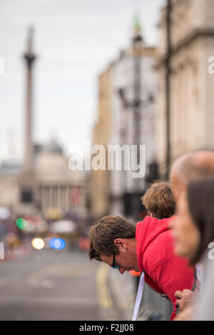 Ein Fan, beugte sich über die Barriere, die warten auf die Fahrer in der Endphase der Tour von Großbritannien 2015 in London UK Stockfoto