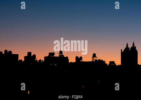 Eine Silhouette Blick auf die Skyline von Manhattan und El Dorado Gebäude auf der Upper West Side bei Sonnenaufgang;  New York City Stockfoto