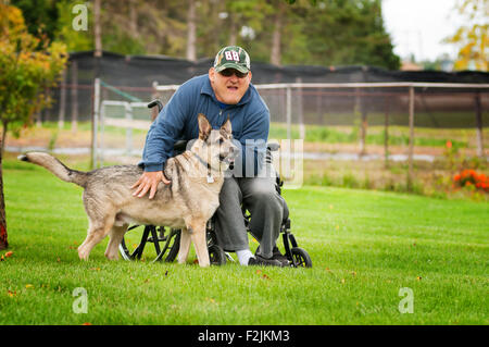 Mann im Rollstuhl mit seinem Hund Stockfoto