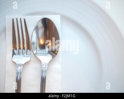 Löffel und Gabel auf Platte Stockfoto