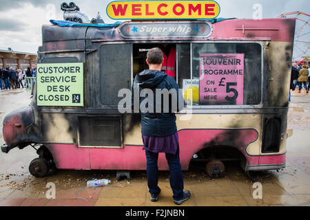 Ein Besucher bei der Kunde Services Desk - geschlossene 24h - in einem ausgebrannten Eis van bei Banksy Dismaland Weston Super Mare Stockfoto