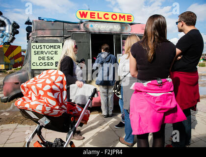 Menschen, die Warteschlangen an den Kundendienst (geschlossene 24 Stunden) in einem ausgebrannten Eis van bei Banksy Dismaland Weston UK Stockfoto