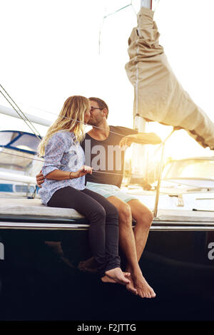 Süße junge Paar küssen auf dem Deck der Yacht bei Sonnenuntergang. Stockfoto