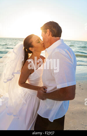 Ein verheiratetes Paar, Braut und Bräutigam, Sonnenuntergang Sonnenaufgang an einem wunderschönen tropischen Strand küssen Stockfoto