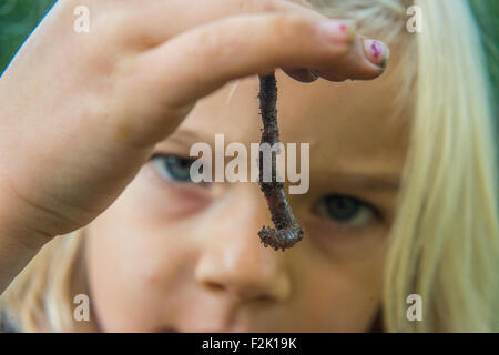 Kind blondes Girl Holding Regenwurm draußen im Garten, Porträt, Sommer, Hand, Garten, Natur Stockfoto