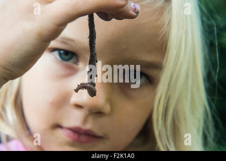 Kind blondes Girl Holding Regenwurm draußen im Garten, Porträt, Sommer, Hand, Garten, Natur Stockfoto