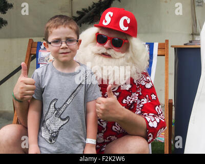 Ein kleiner Junge treffen Santa Clause denen mitten im Sommer Urlaub war. Stockfoto