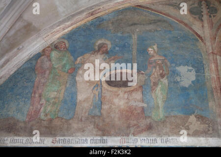 Jesus begegnet die Samariterin am Brunnen. Gotische Wandmalerei aus dem 14. Jahrhundert bekannt als der Emmaus-Zyklus im Kreuzgang des Klosters Emmaus (Na Slovanech) in Prag, Tschechien. Stockfoto