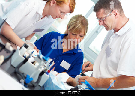 Drei Zahntechniker arbeiten in einem zahntechnischen Labor Stockfoto