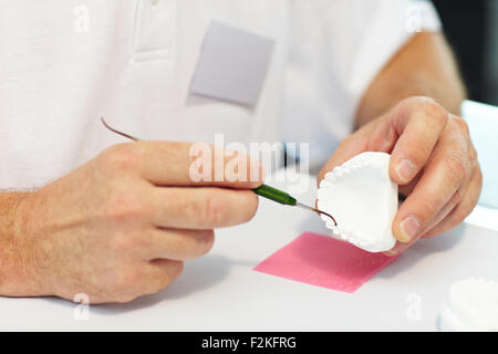 Zahntechniker arbeiten auf Zahnersatz mit einer Sonde Stockfoto