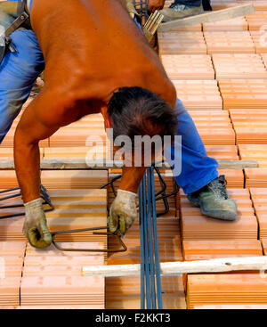 Arbeiter in der Arbeitskleidung macht Metallgerüst Verstärkung für Beton gießen. Stockfoto