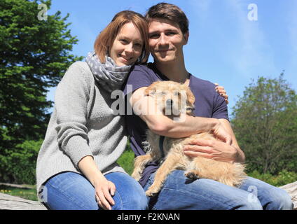 Glückliches junges Paar hält ein Terrier Mischlingshund, North Rhine-Westphalia, Deutschland Stockfoto