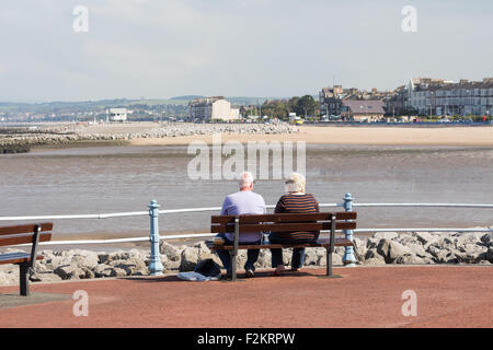 Ein sonniger September-Tag in Morecambe, mit alten Leuten auf einer Bank sitzend und mit Blick auf das Meer mit den Gezeiten Stockfoto