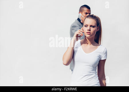 Porträt der jungen Frau telefonieren mit Smartphone vor weißem Hintergrund Stockfoto