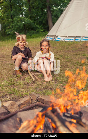 Deutschland, Sachsen, Indianer und Cowboy Party, Kinder sitzen am Lagerfeuer Stockfoto