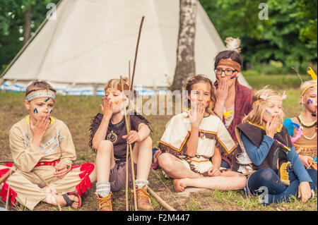 Deutschland, Sachsen, Indianer und Cowboy Party, Kinder sitzen am Lagerfeuer Stockfoto