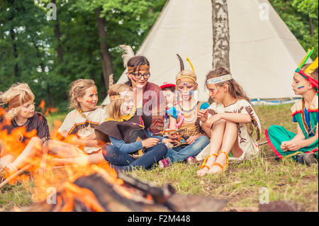 Deutschland, Sachsen, Indianer und Cowboy Party, Kinder sitzen am Lagerfeuer Stockfoto