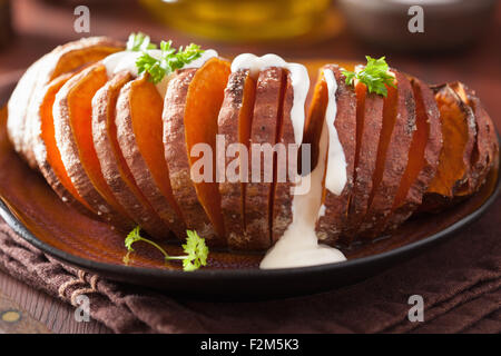 Gebackene Hasselback Kartoffeln mit Sauerrahm Stockfoto