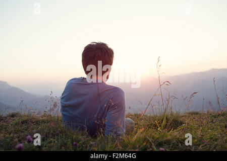 Österreich, Tirol, Unterberghorn, Mann ruht auf Almwiese bei Sonnenuntergang Stockfoto