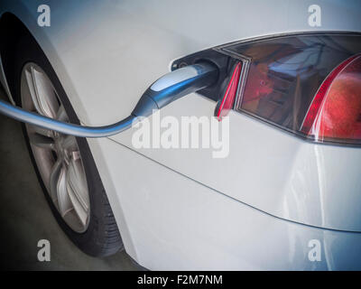 Elektroauto aufgeladen. Aufladen eines Elektroautos mit dem Netzteil eingesteckt Stockfoto