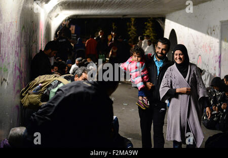 Salzburg, Österreich. 20. Sep, 2015. Eine Flüchtlingsfamilie geht vorbei an andere Flüchtlinge, hauptsächlich aus Syrien, warten auf eine Unterführung für ihre Registrierung und Transport in einem Flüchtlingsheim in Freilassing, Deutschland, an der Grenze zwischen Deutschland und Österreich in der Nähe von Salzburg, Österreich, 20. September 2015. Bildnachweis: Dpa picture Alliance/Alamy Live News Stockfoto