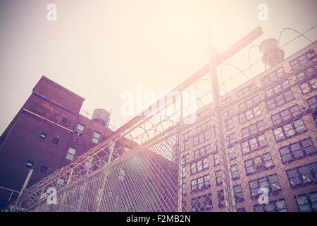 Retro getönten Altbau mit Stacheldrahtzaun, New York, USA geschützt. Stockfoto