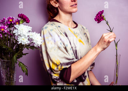 Junge Frau, die Vermittlung von Blumen Stockfoto