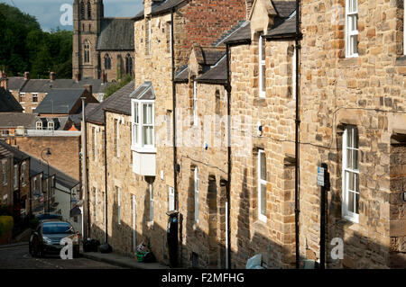 Naturstein-Reihenhäuser auf einem steil abfallenden Straße, Neville Street, Durham City, England, UK Stockfoto