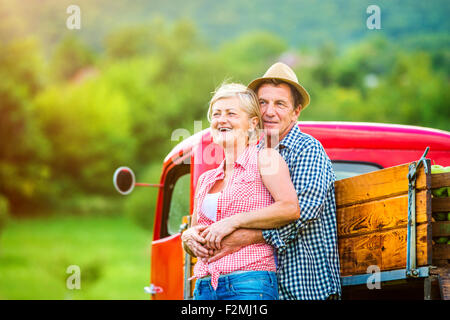 Älteres paar stand neben dem roten Lieferwagen Stockfoto