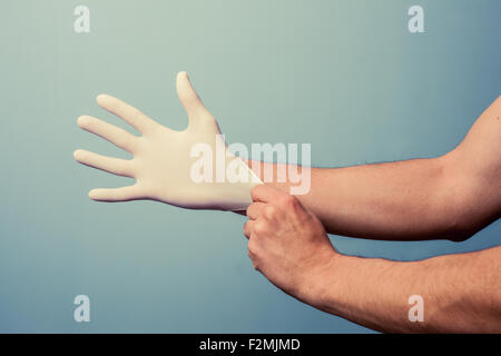 Mann Gummihandschuh anziehen Stockfoto