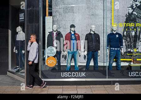 Ein Fußgänger kommt vorbei ein USC Bekleidungsgeschäft auf Princes Street, Edinburgh, Schottland, UK. Stockfoto