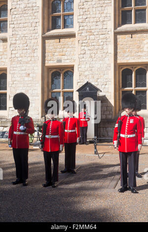 Zeremonie des Wortes mit Gardisten auf Parade, die traditionellen roten Uniformen und Bärenfell tragen Hüte Tower of London Stadt von London Stockfoto