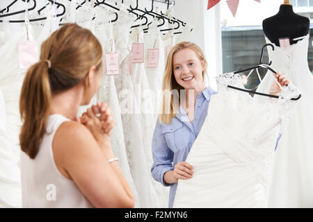 Mutter hilft Tochter Kleid In Bridal Shop wählen Stockfoto