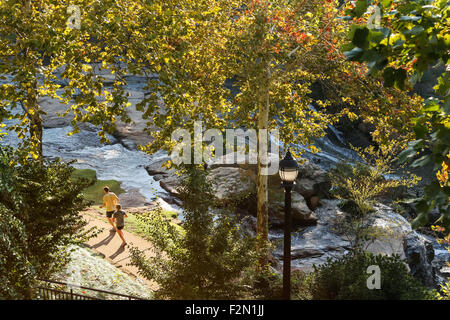 Läufer in Falls Park am Fluss Reedy in der Innenstadt von Greenville, South Carolina. Stockfoto