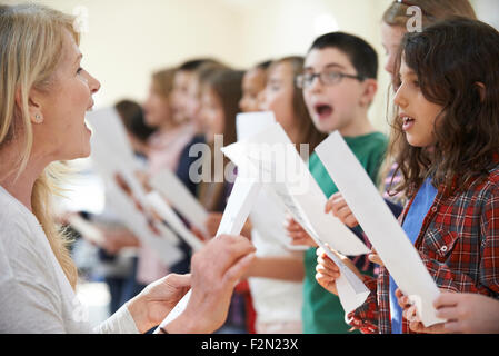 Kinder In Gesangsgruppe gefördert durch Lehrer Stockfoto
