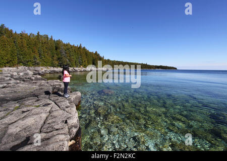 Junge Mädchen stehen auf felsigen Ufer der georgischen Bucht, Bruce Peninsula, Ontario, Kanada. Stockfoto