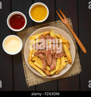 Salchipapas, Pommes Frites und Bratwurst, eine traditionelle Fast-Food in Südamerika gemacht auf Teller serviert Stockfoto