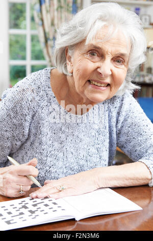 Senior Woman entspannende Kreuzworträtsel zu Hause Stockfoto