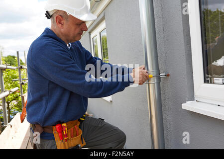 Arbeiter ersetzen, Dachrinnen am Haus Stockfoto