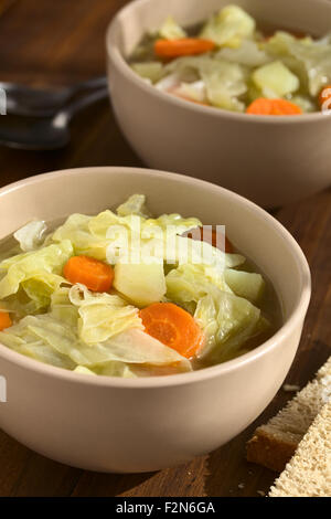 Wirsing, Möhre und Kartoffel-Eintopf oder Suppe in Schalen mit Scheiben Brot auf der Seite Stockfoto