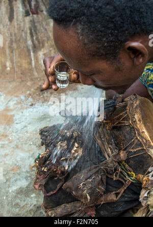 Benin, Westafrika, Bopa, Schlagzeuger spucken Alkohol auf einer Trommel zu wecken seinen Geist vor einer Voodoo-Zeremonie Stockfoto