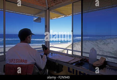 Rettungsschwimmer-Wachturm mit Rettungsschwimmer im Einsatz, Stradbroke Island, Moreton Bay, Teil der Gold Coast, Queensland, Australien. Stockfoto