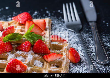 Hausgemachte Waffeln mit frischen Erdbeeren (auf dunklem Hintergrund) Stockfoto