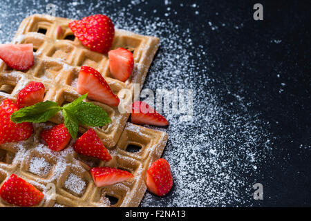 Hausgemachte Waffeln mit frischen Erdbeeren (auf dunklem Hintergrund) Stockfoto
