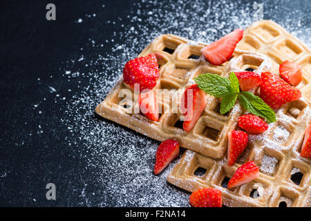 Waffeln mit frischen Erdbeeren (detaillierte Nahaufnahme) auf dunklem Hintergrund Stockfoto