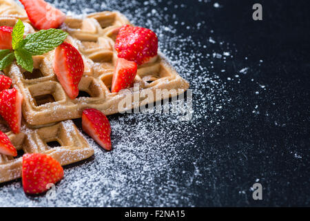 Hausgemachte Waffeln mit frischen Erdbeeren (auf dunklem Hintergrund) Stockfoto